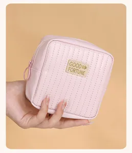 Detailed view of a light pink quilted sanitary napkin and cosmetic storage bag