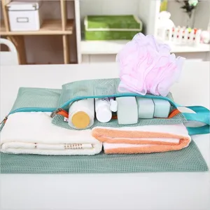 Detail of green mesh travel bag showing toiletries and towel storage capacity