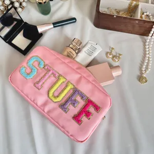 Vue détaillée du sac à cosmétiques en nylon rose avec broderie de lettres STUFF.