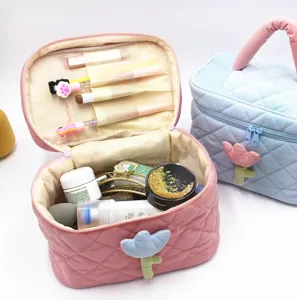 Detailed view of the open corduroy makeup bag filled with cosmetics and brushes