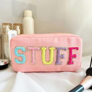 Gros plan d'une trousse de maquillage en nylon rose avec écussons STUFF en chenille