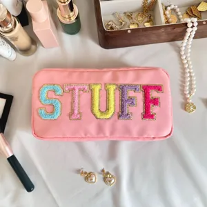 Gros plan sur la broderie en chenille colorée STUFF d'une trousse à maquillage en nylon rose
