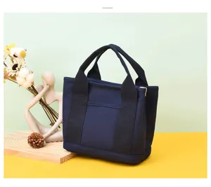 Detail of a minimalist navy canvas tote bag with a front pocket for daily commute.