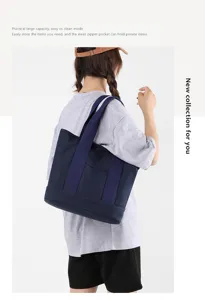 Detail view of a large navy blue canvas tote bag worn by a model for a stylish casual look