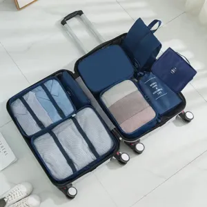 Dunkelblaues Reise-Packwürfel-Set organisiert Kleidung in einem offenen Reisekoffer
