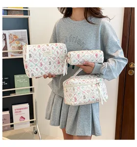 Juego de tres neceseres acolchados con estampado de flores en diferentes tamaños.
