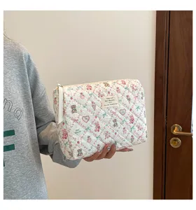 Vista detallada de una bolsa de maquillaje acolchada con lindos patrones de osos y conejos