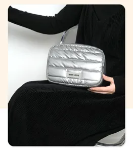 Detailed view of silver quilted puffer cosmetic bag featuring a BEEN LOVE label