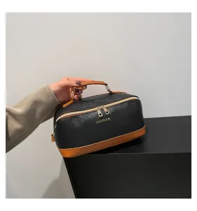 Elegante große schwarze PU-Leder Kosmetiktasche mit braunem Griff in der Hand.