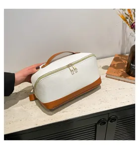 Detaillierte Ansicht der weißen und braunen PU-wasserdichten Kosmetiktasche auf Regal