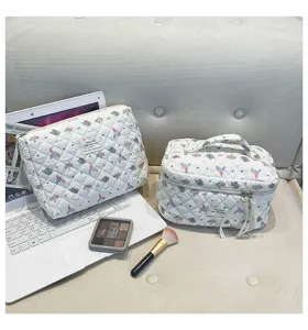 Vista detallada de neceseres acolchados blancos con estampado de elefantes y maquillaje