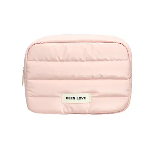 Pink quilted portable cosmetic storage bag with 'BEEN LOVE' label on white background