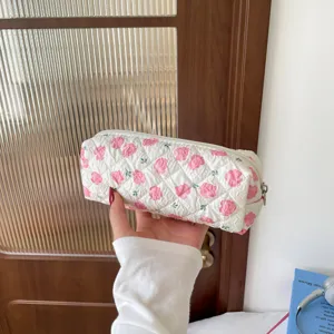 Close-up of quilted cotton pencil case with pink floral rose pattern and zipper detail
