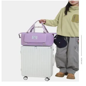 Grand sac de voyage violet imperméable avec manchon pour bagages empilables.