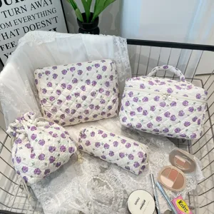 Detailed view of the 4-piece quilted floral cosmetic bag set in white and purple