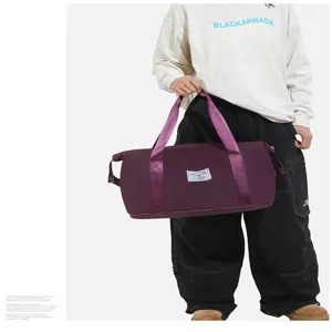 Vue détaillée d'un grand sac de sport violet imperméable tenu par un mannequin en tenue