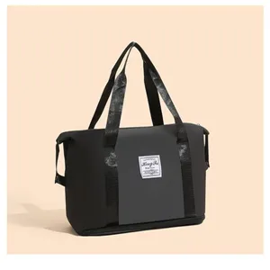 Vue détaillée d'un sac de sport noir imperméable avec empiècement gris et logo