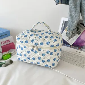 Detailed view of quilted floral cosmetic bag with sturdy handle and dual zippers