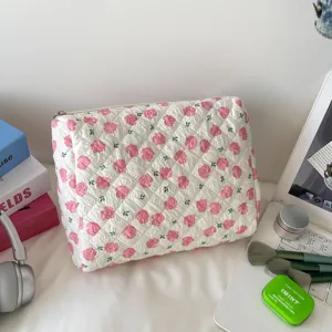 Large capacity quilted floral makeup bag shown in a lifestyle desk setting with accessories.
