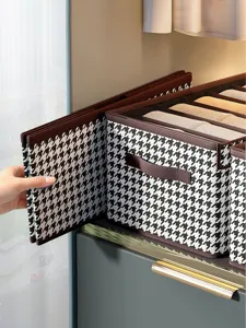 Detail of foldable houndstooth storage box with handle for efficient closet organization.