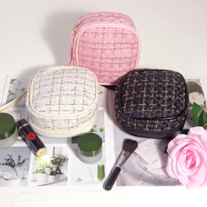 Vue détaillée de petites trousses de maquillage en tweed rose, blanc et noir de voyage