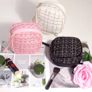 Trousses à cosmétiques élégantes en tweed rose, blanc et noir pour le maquillage.