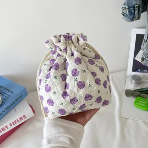 Floral quilted cotton drawstring pouch for cosmetic storage and travel organization.
