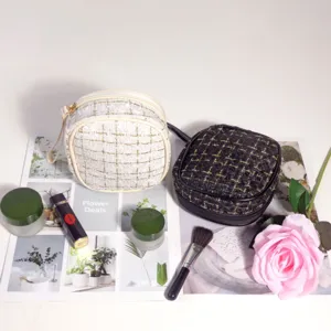 Détail de pochettes cosmétiques en tweed blanc et noir avec des touches dorées élégantes