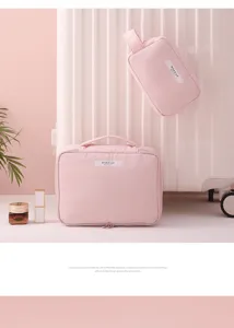 Detailed view of two pink travel cosmetic bags against a white suitcase background.