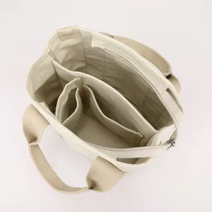 Top view of a cream canvas tote bag showing organized multi-compartment interior for daily use