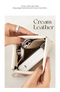 Gros plan montrant la grande capacité et l'ouverture à éclats de la pochette en cuir crème