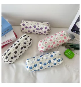Detailed macro shot of four quilted cotton pouches featuring various floral rose patterns
