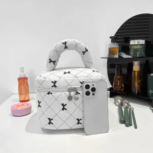 Close-up of white quilted corduroy bag showing bow pattern and phone size reference