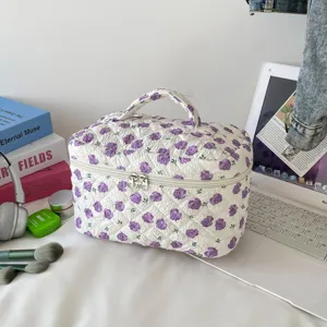 Detailed view of large quilted makeup bag with a purple floral pattern on a desk