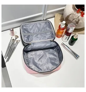 Vista interna di una borsa organizer per trucco da viaggio rosa a doppio strato con divisori