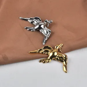 Detalle de broches de paloma de la paz de acero inoxidable pulido en tonos oro y plata