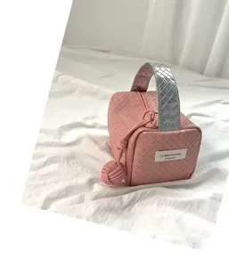 Nahaufnahme der rosa geflochtenen Kosmetiktasche mit silbernem Griff und Anhänger