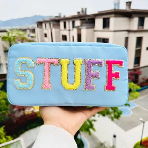 Trousse à maquillage en nylon bleu clair avec broderie chenille "STUFF" colorée.
