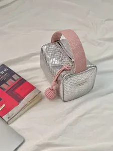 Detailansicht der silber-rosa geflochtenen Kosmetiktasche mit CAT&MOONSHINE-Logo.