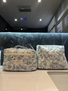 Close-up detail of quilted cotton floral cosmetic bags on a elegant marble bathroom counter.