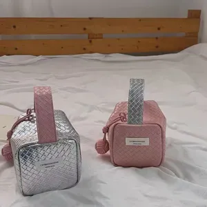 Detailaufnahme der modischen gewebten Kosmetiktaschen in Silber und Rosa Tönen