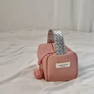 Nahaufnahme der gewebten rosa Kosmetiktasche mit silbernem Griff und Markenetikett.