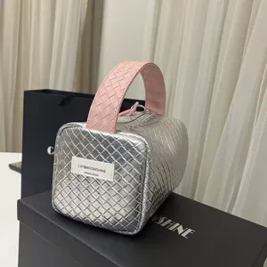 Detail einer silber-rosa geflochtenen Mini-Handtasche mit Intrecciato-Muster.
