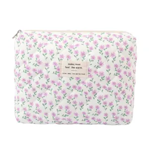 Detail view of a quilted cotton cosmetic bag featuring a purple floral print and fabric label