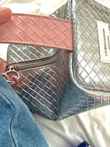 Detailansicht der silbernen und rosa geflochtenen Textur dieser tragbaren Kosmetiktasche