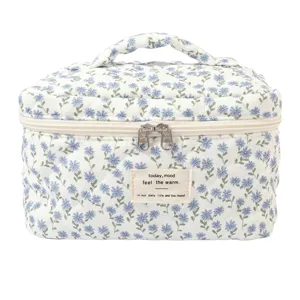 Close-up of floral quilted cotton cosmetic bag with top handle and double zippers