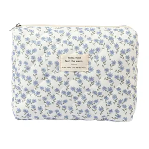 Close-up view of a quilted floral cotton makeup bag featuring a decorative English fabric tag