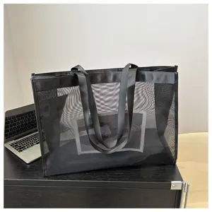 Vista detallada del bolso tote de malla negra con gran capacidad y textura de red.