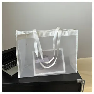 Detalle de un bolso tote minimalista de malla blanca transparente en un escritorio moderno