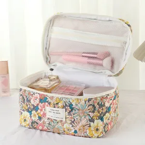 Detailed view of an open floral cotton makeup bag showing interior mesh compartments.